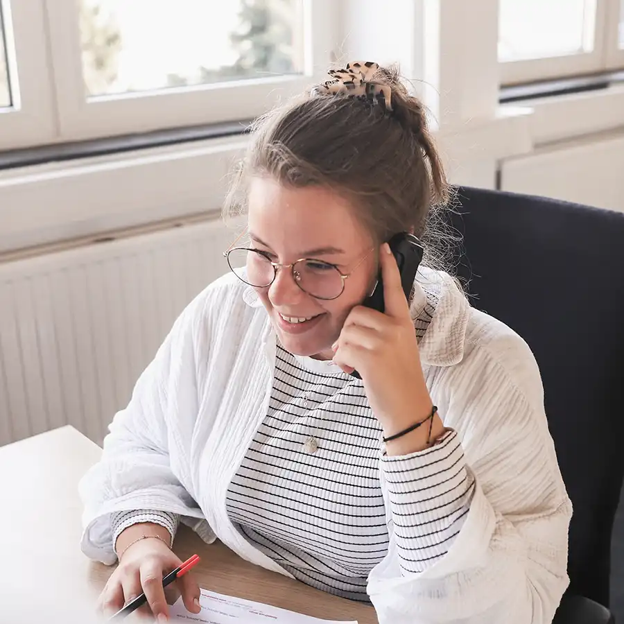Mitarbeiterin der Kreation von BasseDruck am Telefon