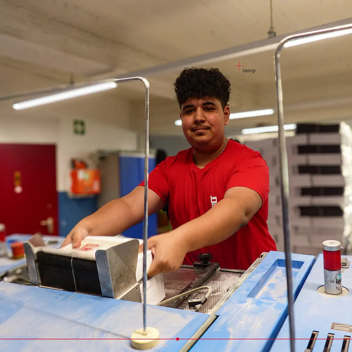 L'apprenti Georgi à une machine dans la production de BasseDruck